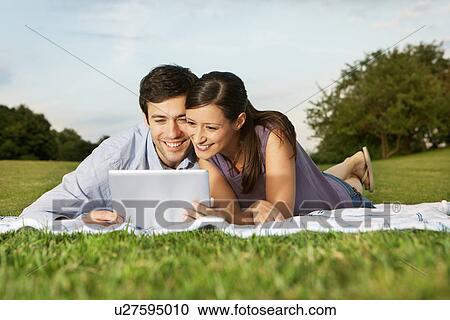 Stock Image - Mid adult couple using digital tablet. Fotosearch