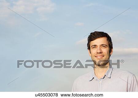 Mid adult man against sky View Large Photo Image Stock Photo - Mid adult man against sky. Fotosearch