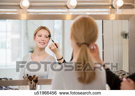Mid adult woman having make-up applied View Large Photo Image Stock Photograph - Mid adult woman having make-up applied. Fotosearch