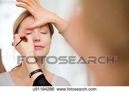 Mid adult woman having make-up applied View Large Photo Image Stock Photograph - Mid adult woman having make-up applied. Fotosearch