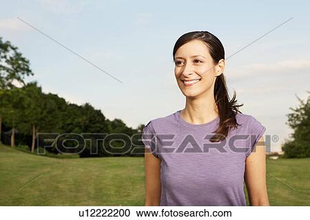 Stock Image - Mid adult woman looking away, smiling. Fotosearch