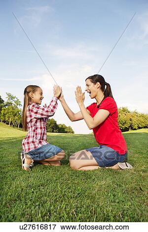 Stock Photo - Mother and daughter playing pat a cake. Fotosearch