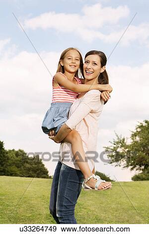 Stock Photo - Mother carrying daughter. Fotosearch