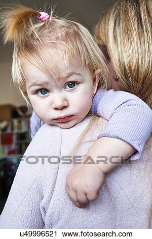 Stock Image - Mother holding toddler daughter over shoulder. Fotosearch