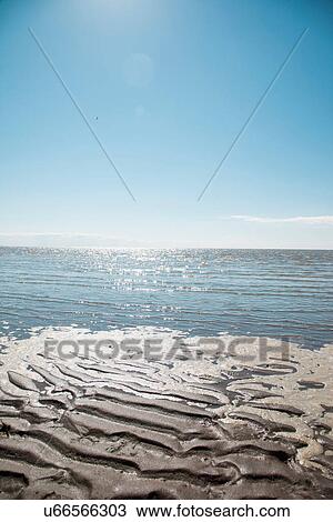 Stock Image - Mudflats with clear blue sky. Fotosearch