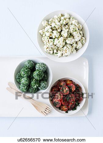 Stock Image - Pickled cauliflower, roasted cherry tomatoes and labna rolled with herbs. Fotosearch
