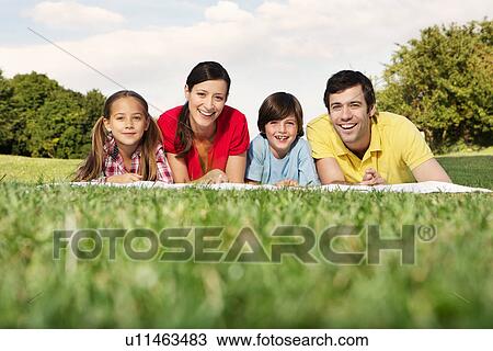 Portrait of family with two children lying on grass View Large Photo Image Stock Image - Portrait of family with two children lying on grass. Fotosearch