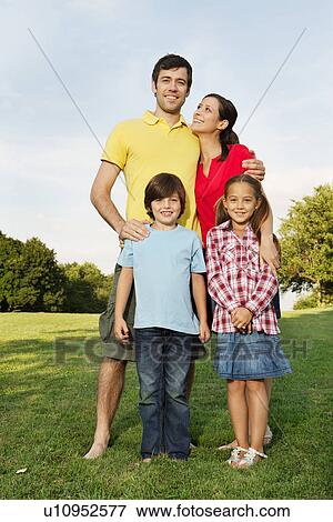 Portrait of family with two children standing on grass View Large Photo Image Stock Photo - Portrait of family with two children standing on grass. Fotosearch