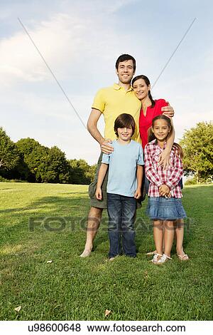 Portrait of family with two children standing on grass View Large Photo Image Stock Photo - Portrait of family with two children standing on grass. Fotosearch