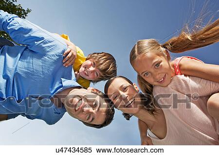 Stock Photography - Portrait of family with two children from below. Fotosearch