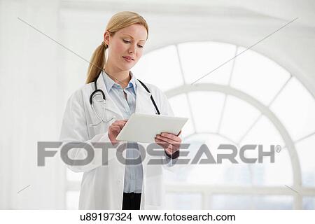 Picture - Portrait of female doctor with stethoscope and digital tablet. Fotosearch