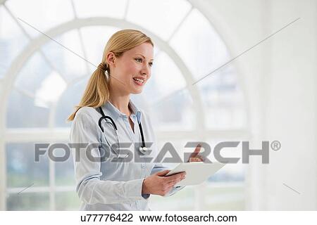 Stock Image - Portrait of female doctor with stethoscope and digital tablet. Fotosearch