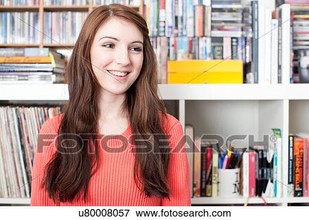 Stock Photo - Portrait of female student in front of bookcase. Fotosearch