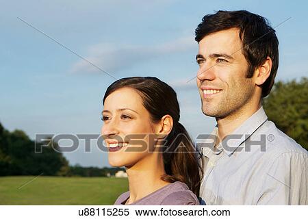 Stock Photography - Portrait of mid adult couple, looking away. Fotosearch