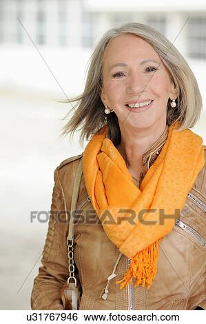 Stock Photograph - Portrait of senior woman in orange scarf. Fotosearch