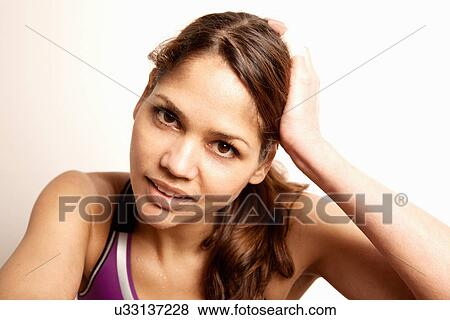 Stock Photo - Portrait of young brunette woman with hand in hair. Fotosearch