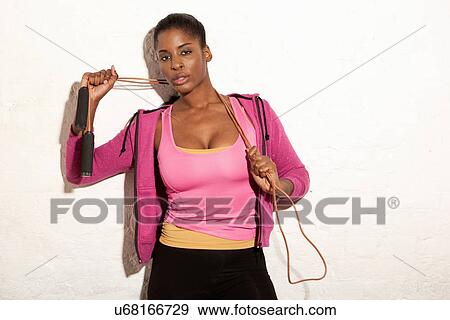 Portrait of young woman holding skipping rope View Large Photo Image Stock Photo - Portrait of young woman holding skipping rope. Fotosearch