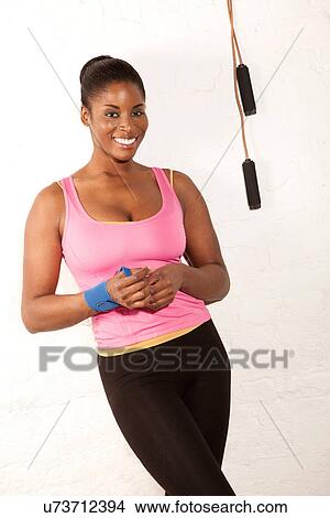 Picture - Portrait of young woman with skipping rope. Fotosearch