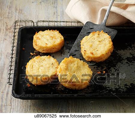Stock Photography - Potato rosti cakes on baking tray and wire rack. Fotosearch