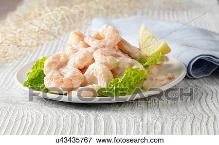 Prawn cocktail with lemon, lettuce and rose marie sauce on white wooden surface with fishing net View Large Photo Image Stock Photo - Prawn cocktail with lemon, lettuce and rose marie sauce on white wooden surface with fishing net. Fotosearch