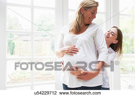 Pregnant mother with teenage daughter by window View Large Photo Image Stock Image - Pregnant mother with teenage daughter by window. Fotosearch