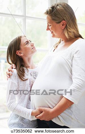 Pregnant mother with teenage daughter by window View Large Photo Image Stock Image - Pregnant mother with teenage daughter by window. Fotosearch