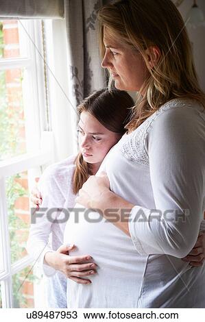 Pregnant mother with teenage daughter looking through window View Large Photo Image Stock Image - Pregnant mother with teenage daughter looking through window. Fotosearch