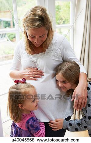 Stock Photo - Pregnant mother with two daughters. Fotosearch