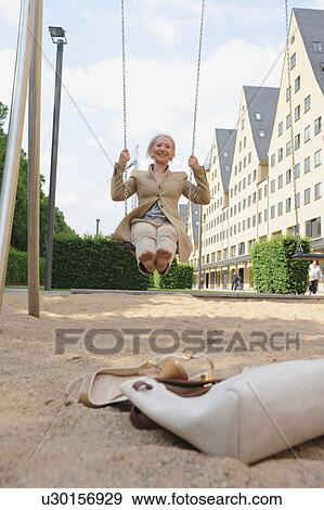 Senior woman on playground swing View Large Photo Image Stock Photo - Senior woman on playground swing. Fotosearch