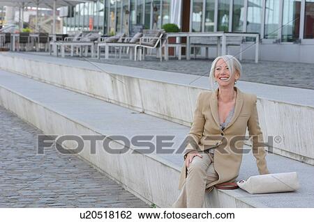 Senior woman sitting on steps in city View Large Photo Image Stock Image - Senior woman sitting on steps in city. Fotosearch