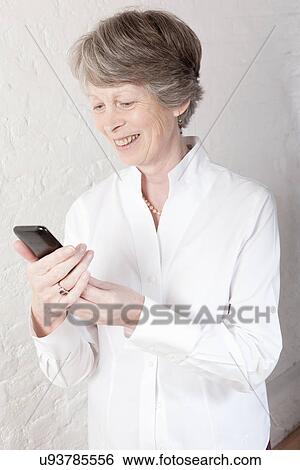 Stock Photograph - Senior woman using smartphone. Fotosearch