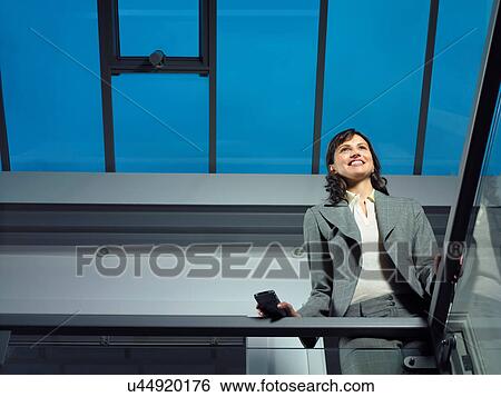 Smart lady in corporate environment with mobile phone View Large Photo Image Stock Photograph - Smart lady in corporate environment with mobile phone. Fotosearch