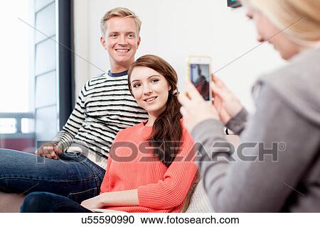 Stock Image - Student using camera phone to photograph friends. Fotosearch