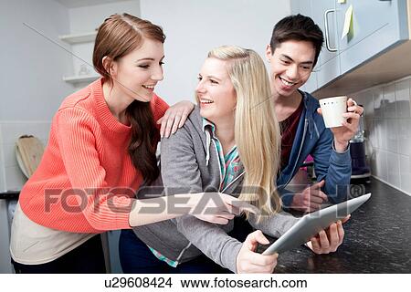 Students in kitchen using digital tablet View Large Photo Image Picture - Students in kitchen using digital tablet. Fotosearch