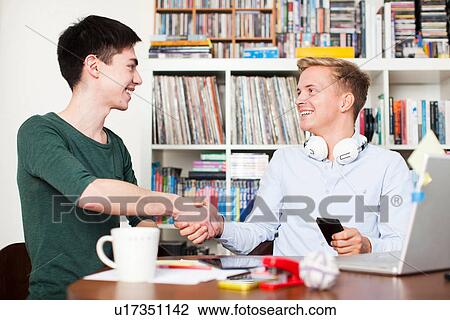 Students shaking hands at desk View Large Photo Image Stock Image - Students shaking hands at desk. Fotosearch