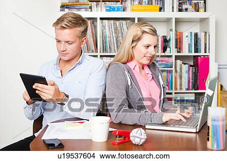 Picture - Students working on laptop and digital tablet. Fotosearch