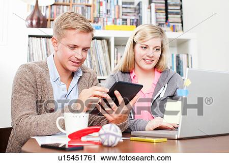 Stock Image - Students working on laptop and digital tablet. Fotosearch