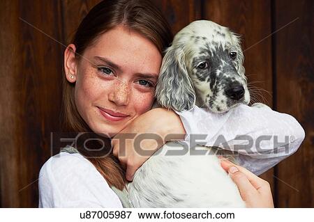 Stock Photo - Teenage girl holding dog. Fotosearch