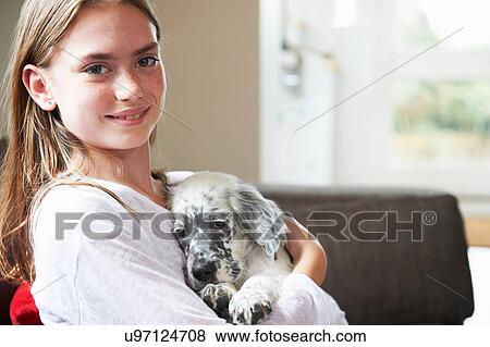 Stock Photo - Teenage girl holding dog. Fotosearch