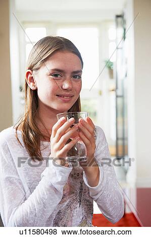 Teenage girl holding glass of water View Large Photo Image Stock Photo - Teenage girl holding glass of water. Fotosearch