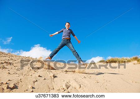 Teenage girl jumping on sand View Large Photo Image Stock Image - Teenage girl jumping on sand. Fotosearch