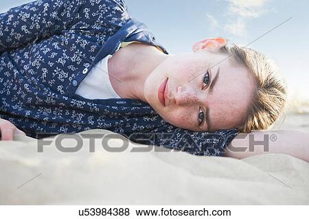 Stock Photo - Teenage girl lying on beach. Fotosearch
