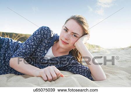 Stock Photo - Teenage girl lying on beach. Fotosearch