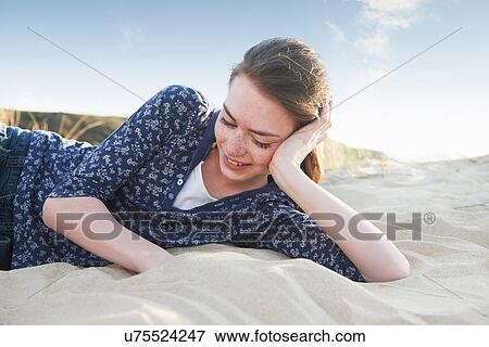 Teenage girl lying on beach View Large Photo Image Stock Photo - Teenage girl lying on beach. Fotosearch