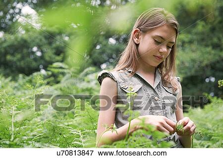 Stock Photo - Teenage girl touching bracken in forest. Fotosearch