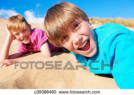 Two blonde haired boys lying on beach View Large Photo Image Stock Image - Two blonde haired boys lying on beach. Fotosearch