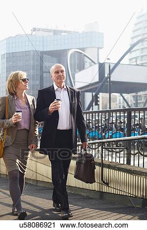 Stock Image - Two businesspeople walking in city. Fotosearch