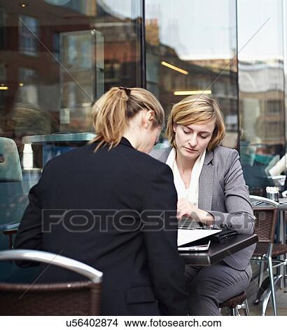 Two businesswomen meeting at outdoor cafe View Large Photo Image Picture - Two businesswomen meeting at outdoor cafe. Fotosearch