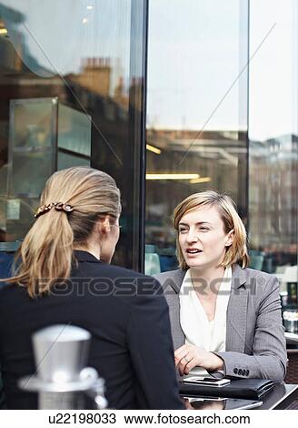 Two businesswomen meeting at outdoor cafe View Large Photo Image Stock Image - Two businesswomen meeting at outdoor cafe. Fotosearch