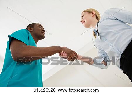 Two doctors shaking hands, low angle View Large Photo Image Stock Image - Two doctors shaking hands, low angle. Fotosearch